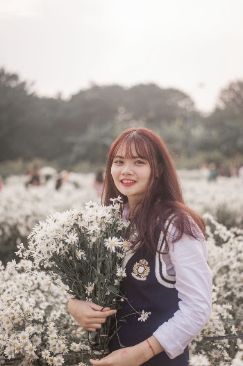 Photo of Woman Holding Flowers