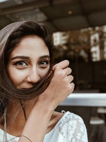 Photo of Woman Holding Her Hair over Her Mouth