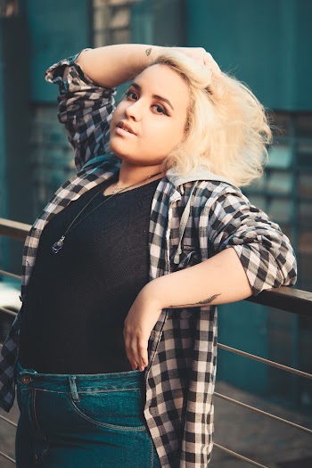 Photo of Woman Holding Her Hair While Leaning on Railings