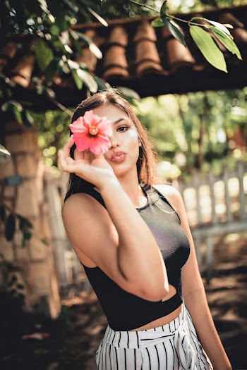 Photo of Woman Holding Hibiscus Flower Hiding Face