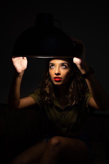 Photo of Woman Holding Lighted Ceiling Lamp