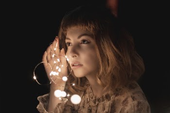 Photo of Woman Holding Lit String Lights
