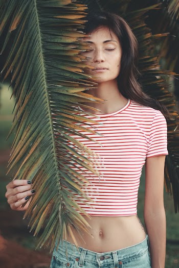 Photo of Woman Holding Palm Leaf