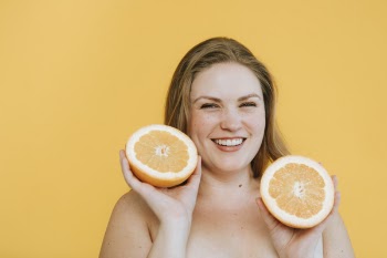 Photo of Woman Holding Slice Orange