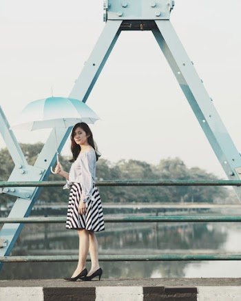 Photo of Woman Holding Umbrella on Bridge