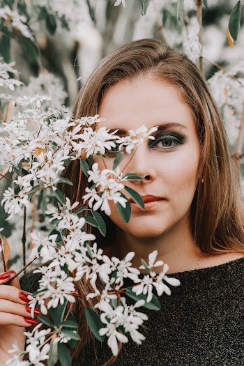 Photo of Woman Holding White Petaled Flowers