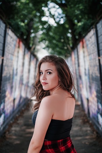 Photo of Woman in Black and Red Dress Standing in an Alley Looking Back
