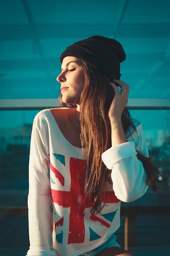 Photo of Woman in Black Beanie Hat and White Top Posing With Her Eyes Closed