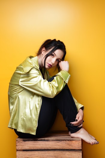 Photo of Woman in Black Bottoms and Golden Top Sitting on Wooden Crate