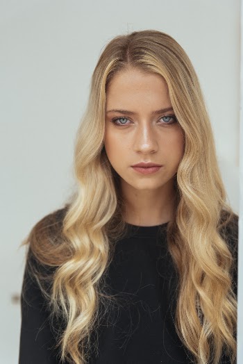 Photo of Woman in Black Crew Neck Shirt With Long Wavy Blond Hair