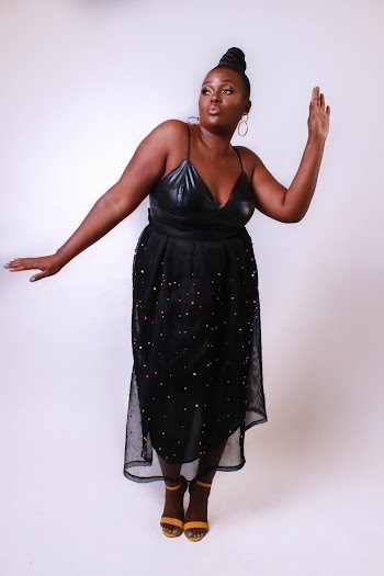 Photo of Woman in Black Dress Posing In Front of White Background