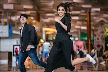 Photo of Woman in Black Dress Running Beside Man