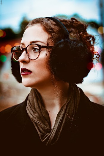 Photo of Woman in Black Earmuffs and Eyeglasses Looking Away
