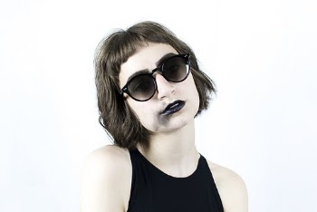 Photo of Woman in Black Sleeveless Top and Sunglasses With Smudged Black Lipstick