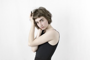 Photo of Woman in Black Sleeveless Top Posing In Front of White Background