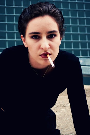 Photo of Woman in Black Sweatshirt Posing With Cigarette in Mouth