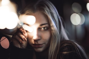 Photo of Woman in Black Top Holding String Lights