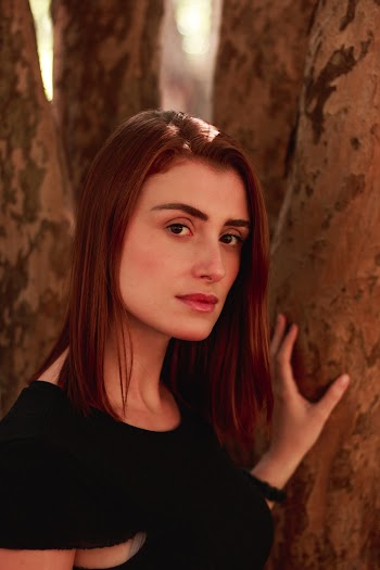 Photo of Woman in Black Top Posing Beside Tree