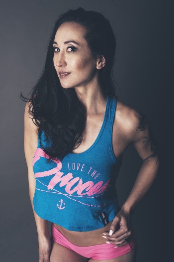 Photo of Woman in Blue Tank Top and Pink Panties Posing In Front of Gray Background