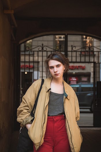 Photo of Woman in Brown Zip-up Jacket and Red Trousers Posing