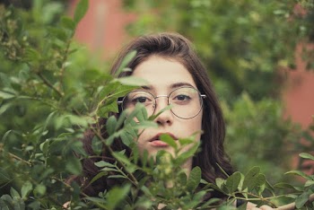 Photo of Woman in Eyeglasses Behind Green Leafed Plants