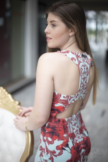 Photo of Woman in Floral Dress Posing Next to Chair