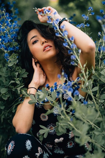 Photo of Woman in Floral outfit Posing by Blue Flowering Plant