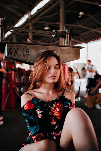 Photo of Woman in Floral Top Sitting with Her Eyes Closed