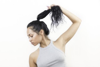Photo of Woman in Gray Sleeveless Top Holding Her Hair