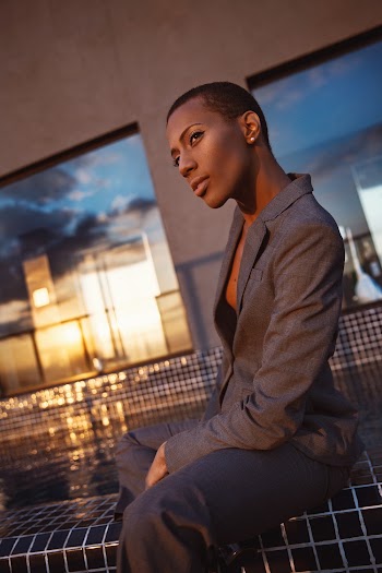 Photo of Woman in Gray Suit Sitting by Pool Side Posing
