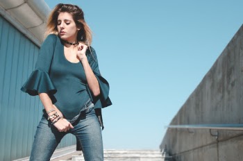 Photo of Woman in Green Bodysuit and Blue Denim Jeans Posing