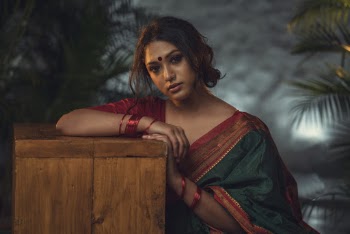Photo of Woman in Green Saree Dress Leaning on Wooden Block