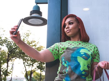 Photo of Woman in Green Shirt Taking Selfie