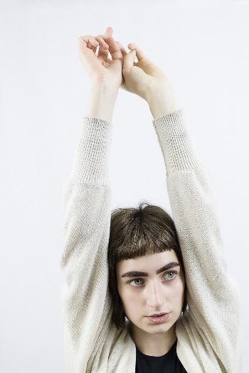 Photo of Woman in Grey Cardigan With Her Hands Raised