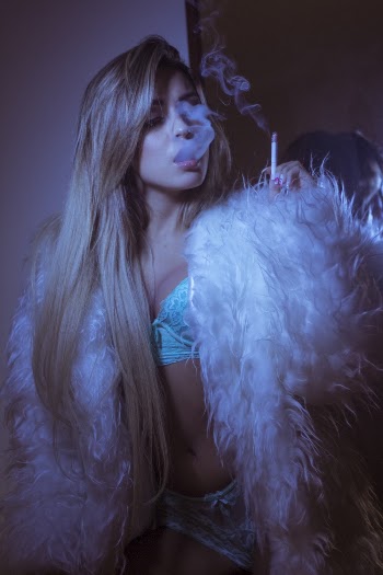 Photo of Woman in Lingerie and Faux Fur Coat Smoking Cigarette
