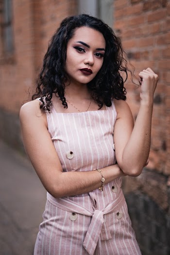 Photo of Woman in Pink and White Pinstripe Outfit Posing