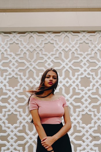 Photo of Woman in Pink Top and Black Skirt Posing