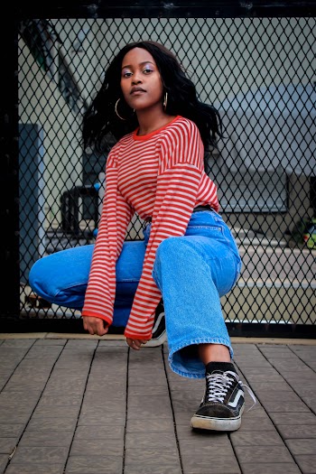 Photo of Woman in Red and White Striped Long-sleeved Shirt and Blue Jeans Squat Posing