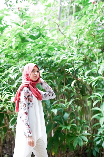 Photo of Woman in Red Headscarf Posing Near Green Plants