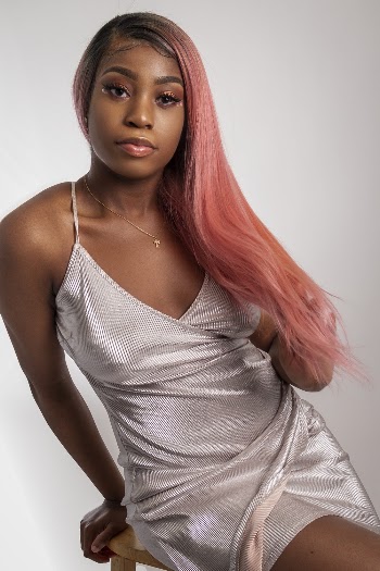 Photo of Woman in Silver Dress Sitting On Wooden Chair Posing