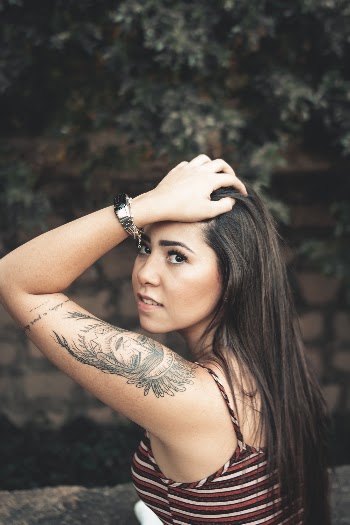 Photo of Woman in Spaghetti-strap Top Holding Her Hair