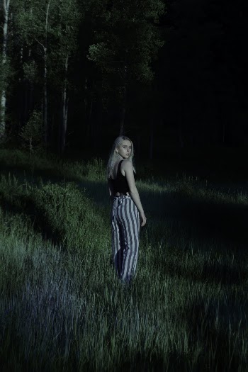 Photo of Woman in Standing in Grass Field Posing While Looking Back