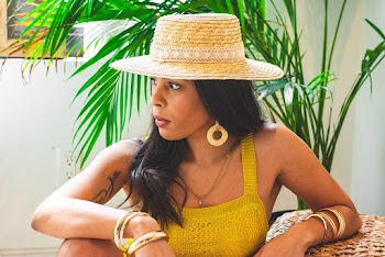 Photo of Woman in Sun Hat and Yellow Top Sitting on Chair Looking Away