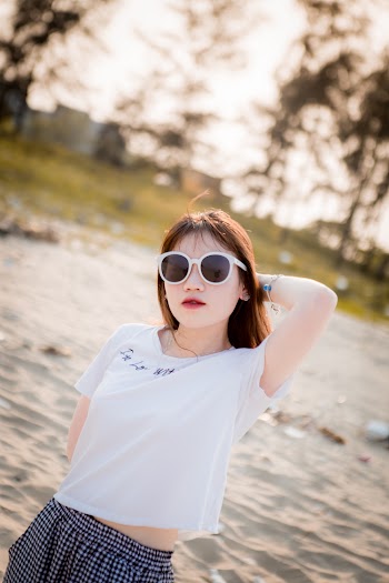 Photo of Woman in Sunglasses and White T-shirt Posing