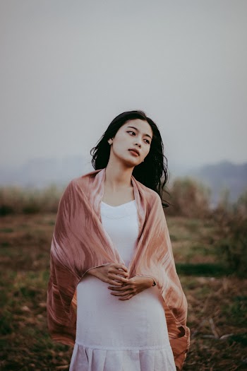 Photo of Woman in White Dress and Beige Scarf Posing