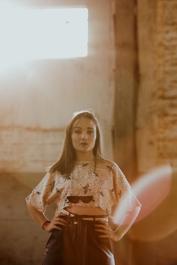 Photo of Woman in White Floral Sleeved Crop Top Standing Akimbo