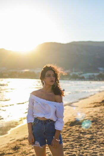 Photo of Woman in White Off Shoulder Dress on the Seashore