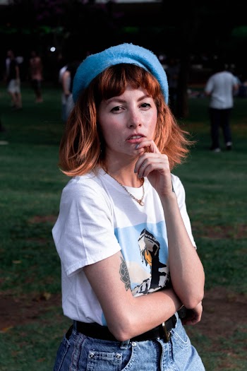 Photo of Woman in White T-shirt and Blue Knit Cap Posing