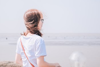Photo of Woman in White T-shirt Overlooking the Horizon