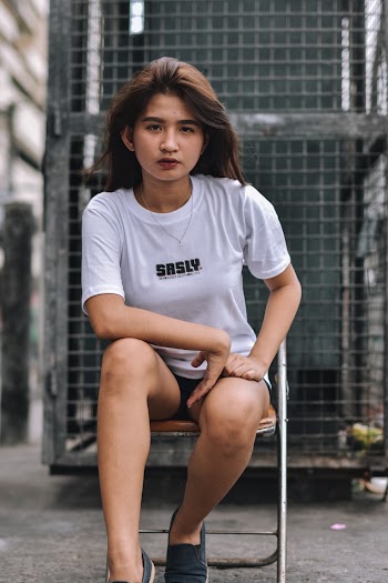 Photo of Woman in White T-shirt Sitting on Steel Folding Chair